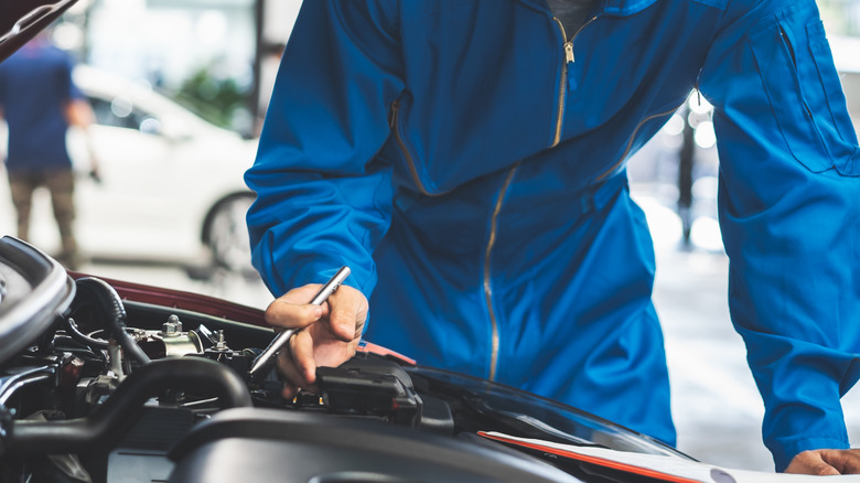 car mechanic inspecting engine