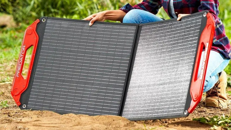 A person holding a Predator solar panel.