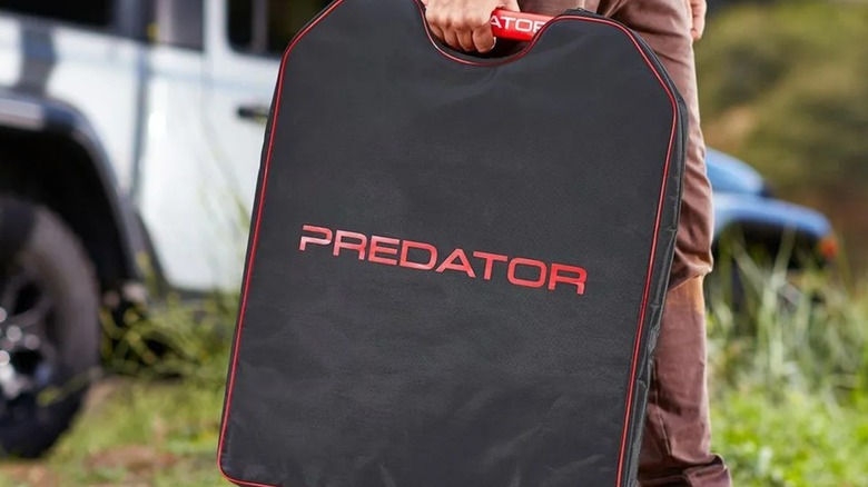 A person holding a Predator solar panel bag.