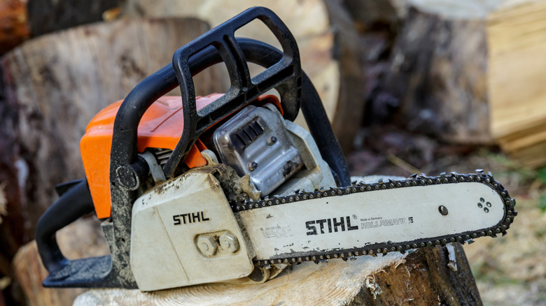 STIHL chainsaw with orange handle on a wooden stump