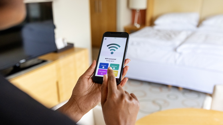 A person adjusting Wi-Fi router settings through their smartphone.