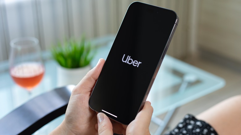 Close-up of a person holding a phone showing the Uber logo