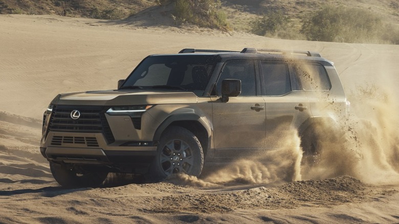Front 3/4 view of Lexus GX throwing up sand in desert setting
