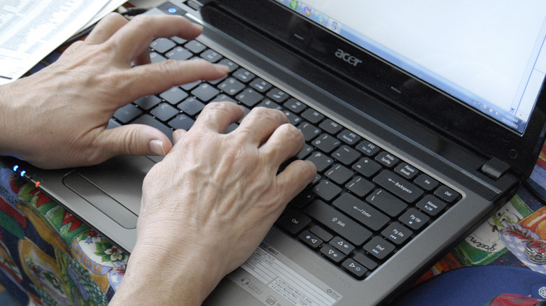 Hands typing on Acer laptop