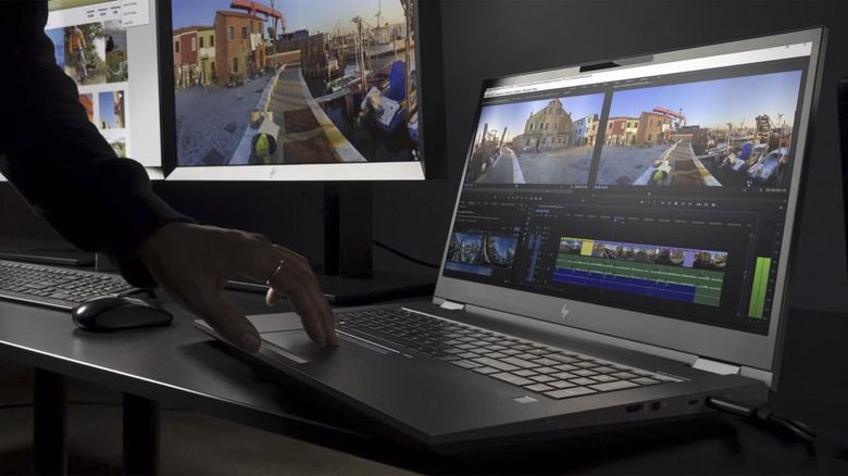 Person using HP laptop with monitors