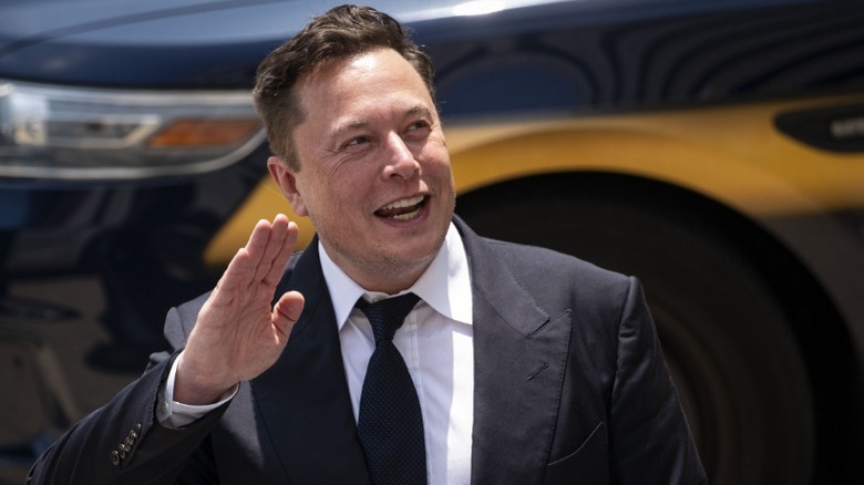 Elon Musk waving in front of vehicle