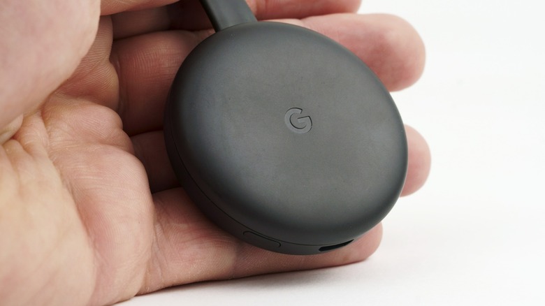 Person holding a Chromecast dongle