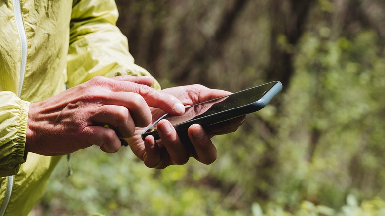 person using iPhone hiking