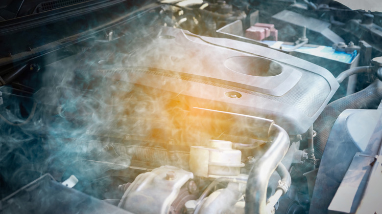 Car engine overheats causing smoke from the damage to the engine.