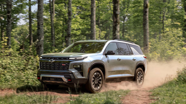 Chevrolet Traverse driving through a wooded landscape