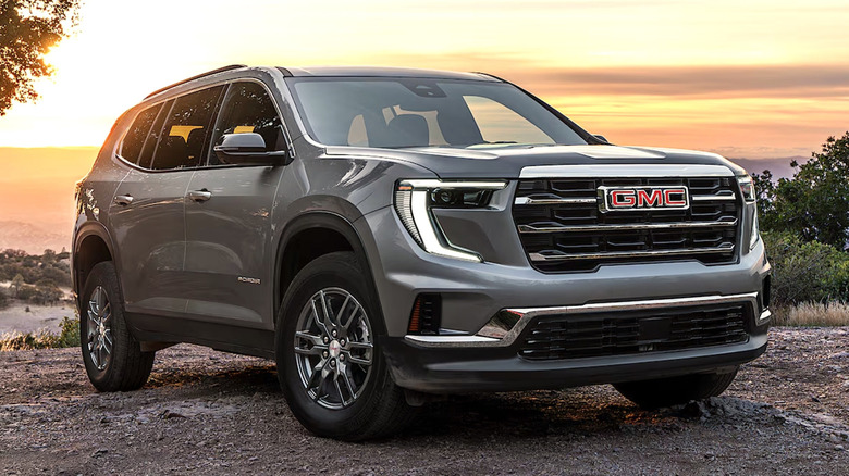 GMC Acadia parked on a mountain at sunrise