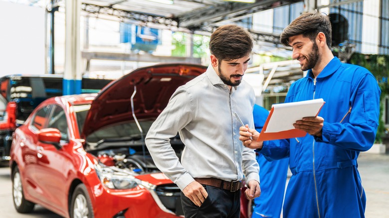 car mechanic speaking to customer