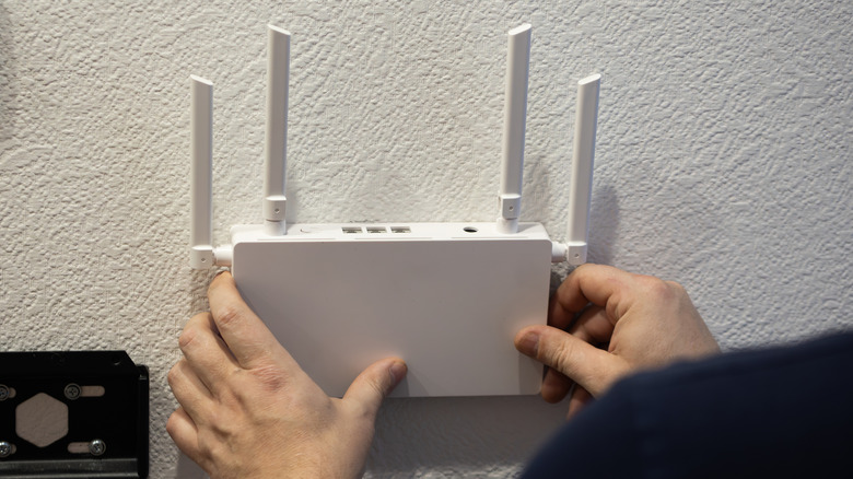 Person holding a router installed on the wall