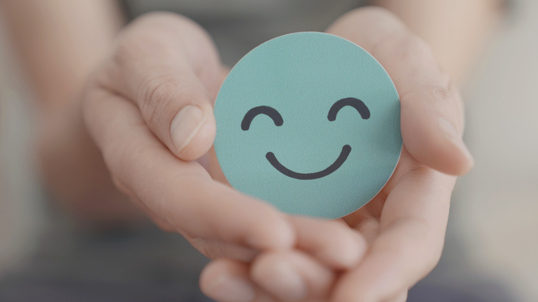 hands holding smiley face emote