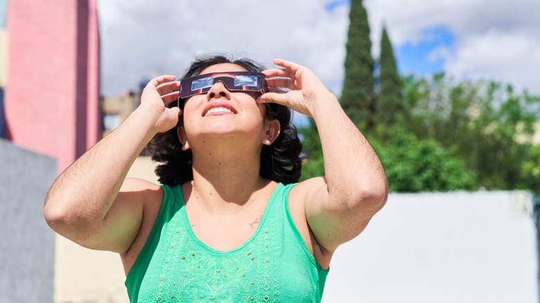 Woman in green dress watching a solar eclipse