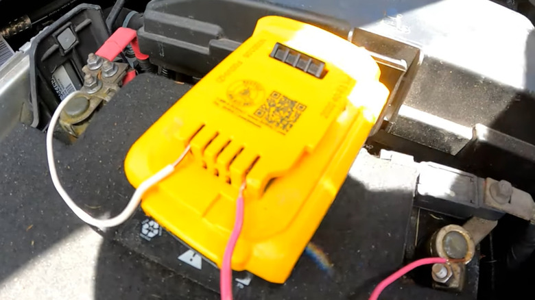 20 Volts DeWalt power tool battery clipped onto a car battery