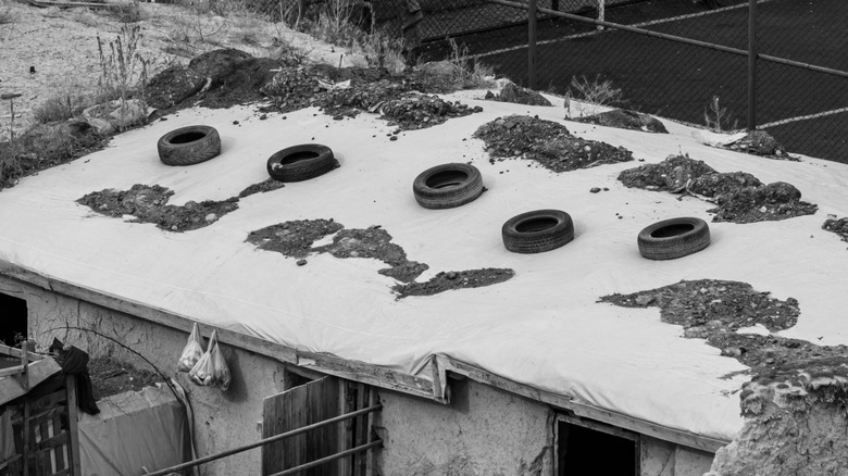 Car tires placed on the roof of a home