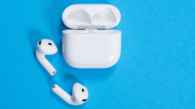 AirPods 4 wireless earbuds and open charging case on a vibrant blue background