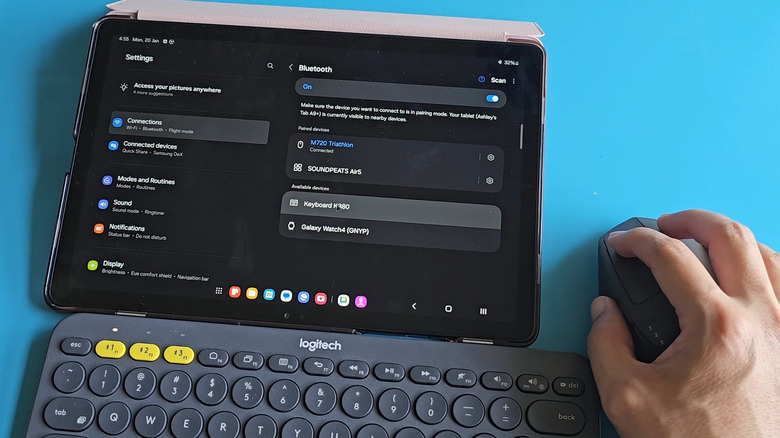 Man connecting Bluetooth keyboard to tablet using a mouse