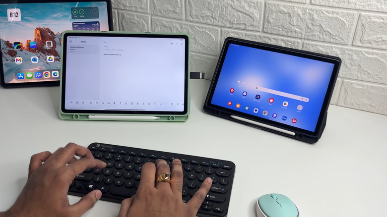 Man using a Bluetooth keyboard with two tablets on a table