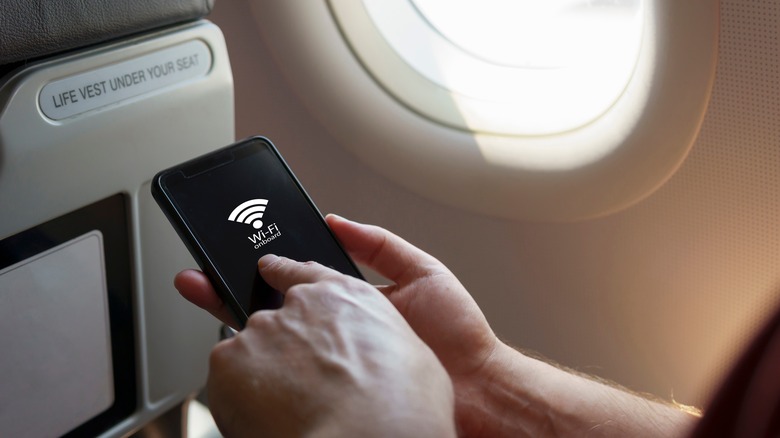 Person using wi-fi sitting on airplane.