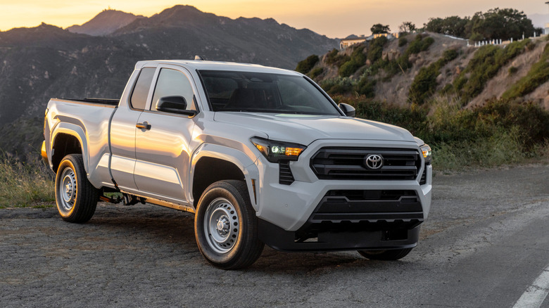 Front three-quarters view of a white 2026 Toyota Tacoma SR parked on mountain road.