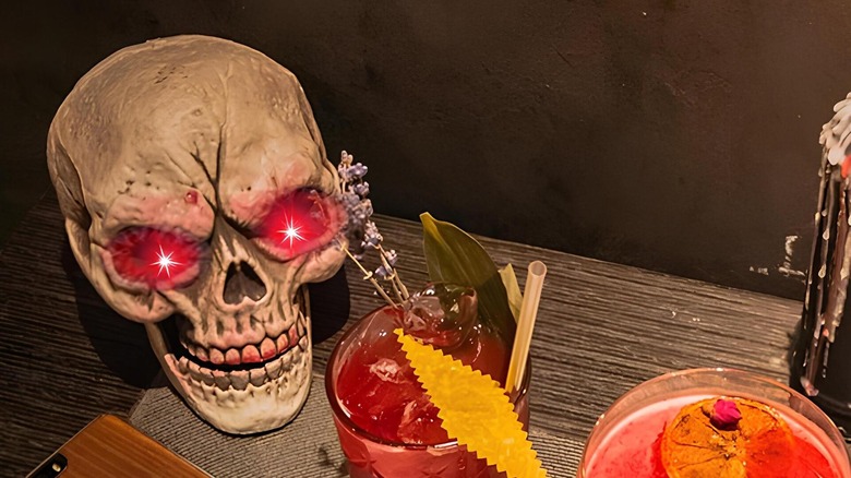 A skull with red lit eyes on a dining table