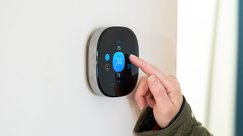 Person adjusting thermostat