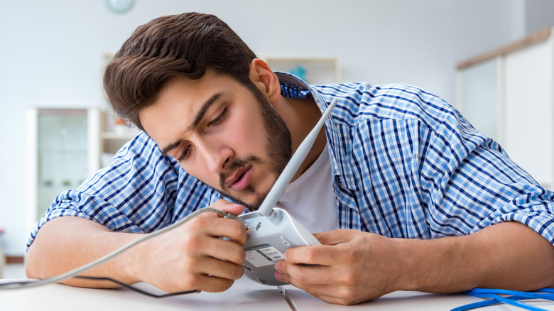 Man plugging a cable into a router