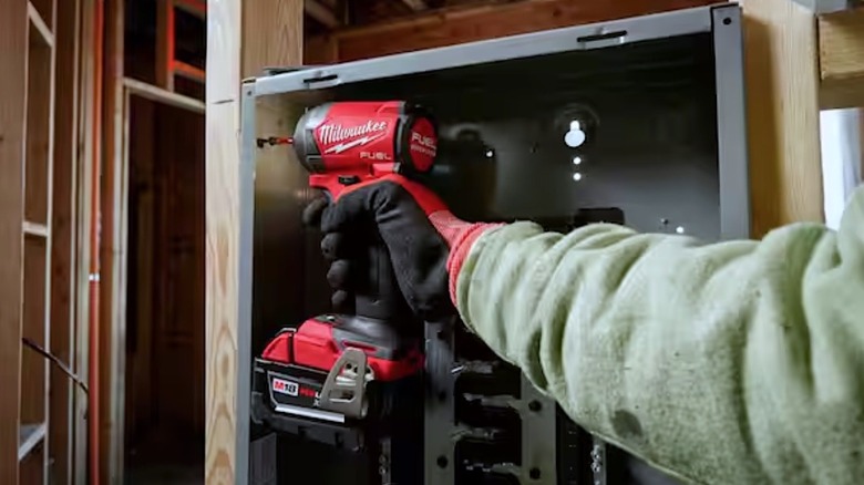 Person using Milwaukee impact driver