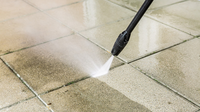 Person pressure washing walkway