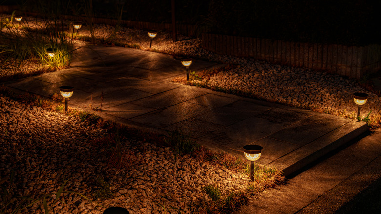 Home garden path lined with stones and lit by LED lights