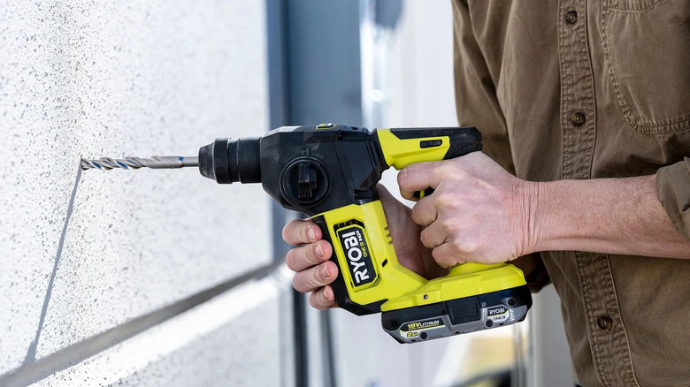 Person drilling into a wall with a Ryobi 18V One+ drill