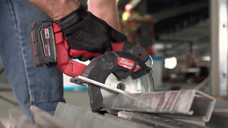 Person using a Milwaukee Tools handheld circular saw