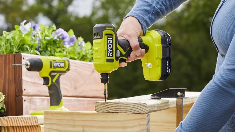 Person attaching board with Ryobi One+ ¼-inch Hex Screwdriver