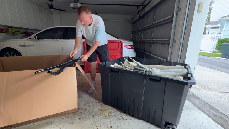 man putting halloween decorations in massive home depot tote