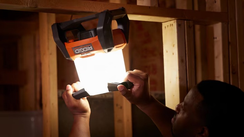 Man hanging a Ridgid 18V Cordless 360° Area Light