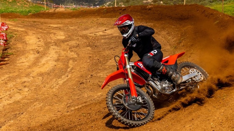 A motocross rider railing a berm on a Honda dirt bike.