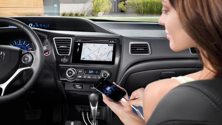 A smartphone plugged into the 2014 Honda Civic's HondaLink infotainment syste,