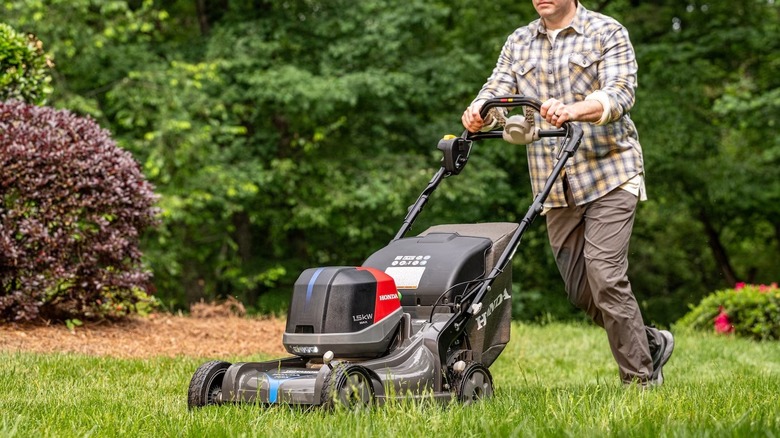 A man using an electric Honda mower