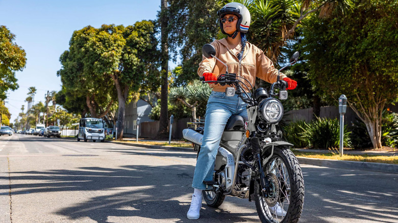 Person on a silver Honda Trail125 motorcycle