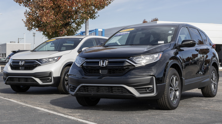 White Honda SUV parked in front of a dealership