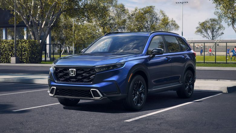 2026 Honda CR-V Sport Touring Hybrid in blue in a parking lot, front 3/4 view