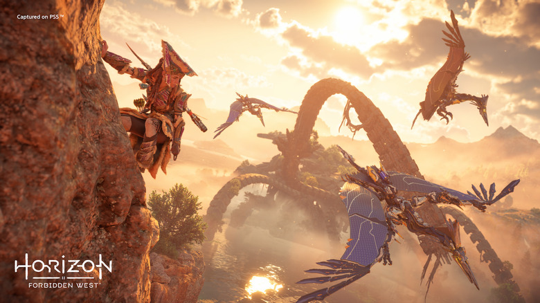 Aloy climbing a cliff with machines