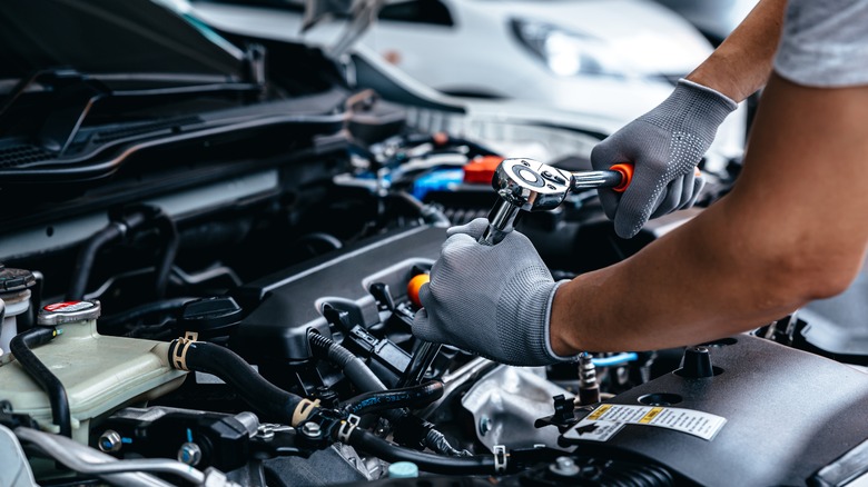 man working on car engine