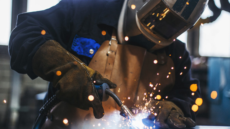 Close-up of a person in protective gear welding.