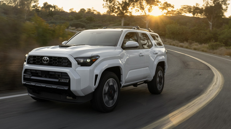 Front 3/4 view of white Toyota 4Runner on rural road.