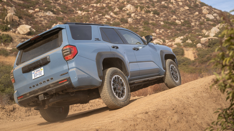 Rear 3/4 view of blue Toyota 4Runner TRD Off-Road on desert trail.
