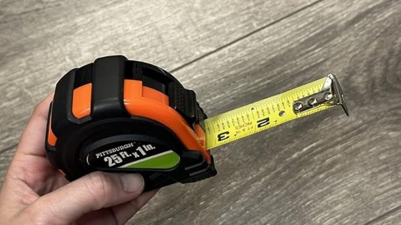 User holding extended Pittsburgh tape measurer