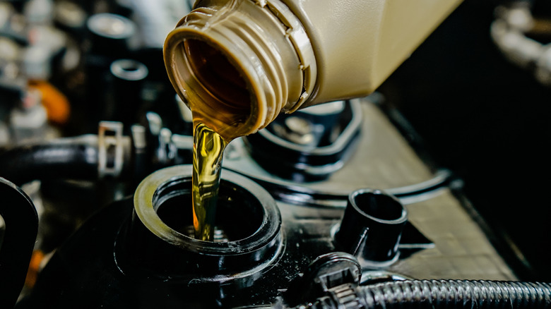 Car engine oil being poured into an engine